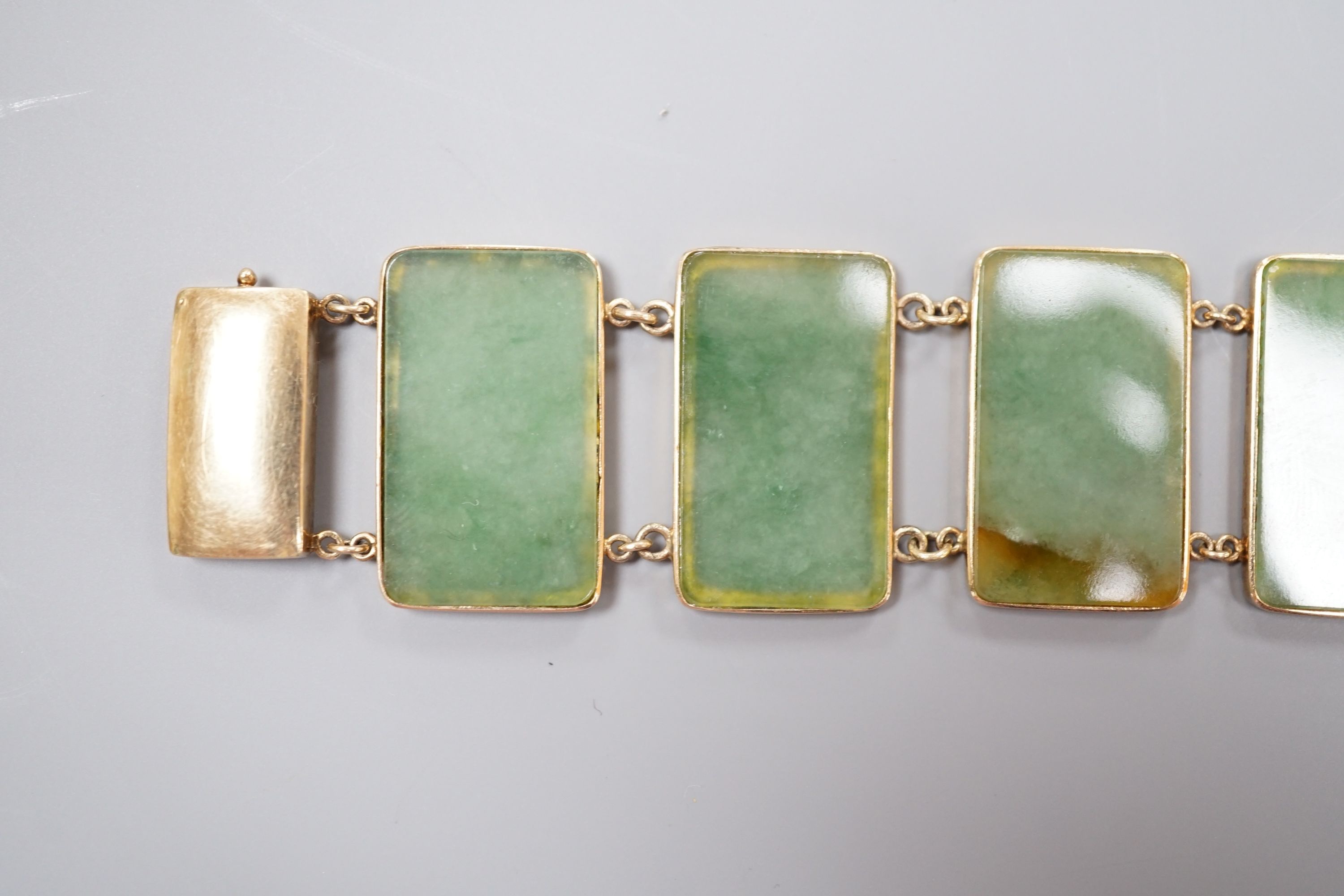 A 585 yellow metal and jade bracelet, set with eight rectangular panels, 18cm, gross weight 26.5 grams.
